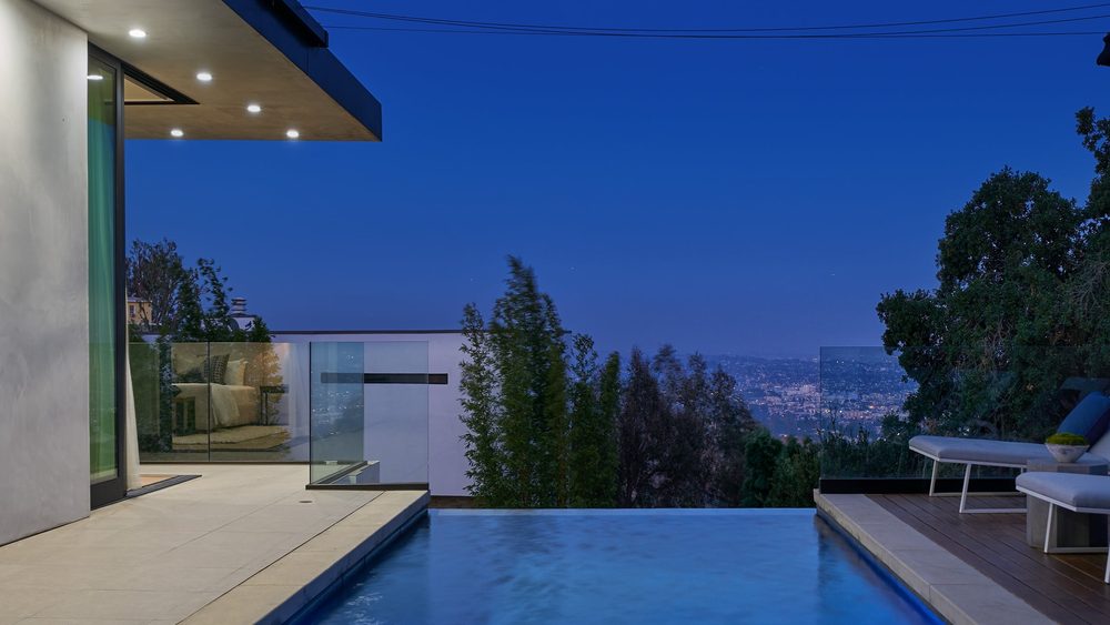 Twilight pool terrace and city view at The Hollywood Marvel, a completed Thornton Development Group home