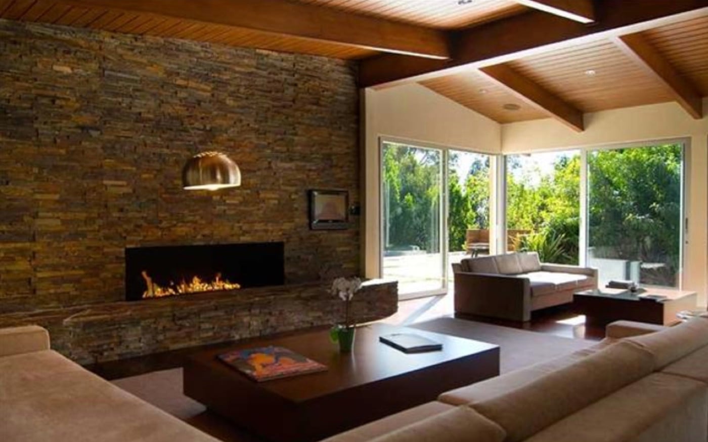 Living room with stone fireplace and exposed beam ceilings